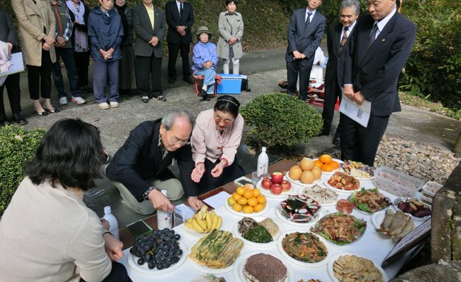 韓会長がお酒を供える